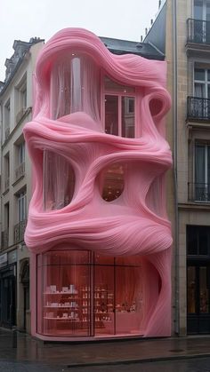 a pink building that is on the side of a street