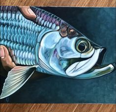 a painting of a fish with its mouth open and it's tongue out on a wooden surface