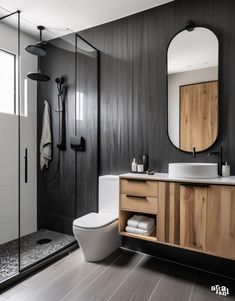 a modern bathroom with black walls and wood accents on the vanity, toilet and shower