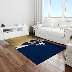 a living room filled with furniture and a rug on top of a hard wood floor