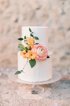 a white cake with yellow and pink flowers on top