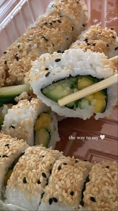 sushi rolls with sesame seeds and cucumber on them in a plastic container