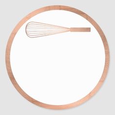 a whisk on top of a white plate with brown trim around the edge