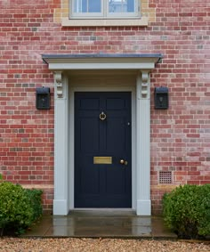 a black door is on the side of a brick building