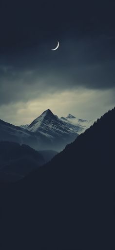 the moon shines brightly in the dark sky above mountains