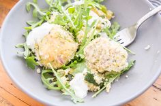 a blue bowl filled with salad and two meat patties on top of green lettuce