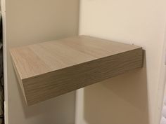 a wooden shelf mounted to the side of a wall