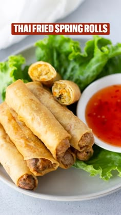 an image of spring rolls on a plate with dipping sauce and lettuce in the background