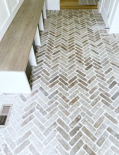 a white and brown herringbone tile floor in a hallway