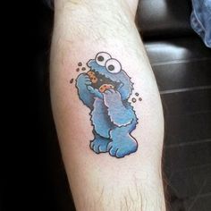 a man's arm with a tattoo of an evil cookie monster