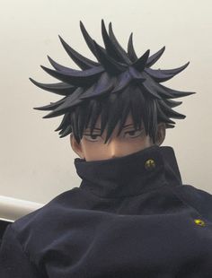 an action figure wearing a black jacket with spikes on it's head and eyes