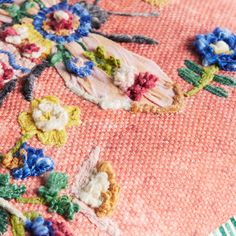 an embroidered piece of cloth with flowers on it