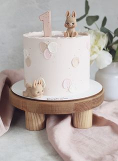 a white cake sitting on top of a wooden stand