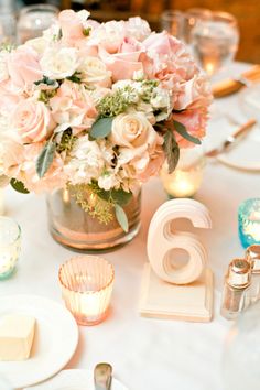 the table is set with flowers and candles