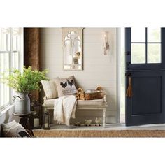 an entryway with a bench and potted plants