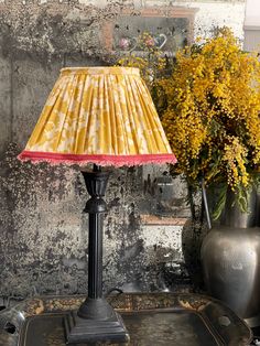 a lamp that is sitting on a table next to some vases with flowers in them