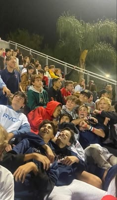 a group of people sitting on top of a bleachers