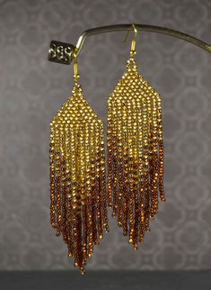 gold beaded earrings hanging from a hook