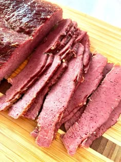 sliced meat sitting on top of a wooden cutting board