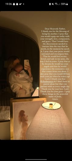 a woman holding a baby in her arms next to a lamp with a poem on it