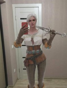 a woman with white hair is taking a selfie in front of a mirror holding a pair of scissors