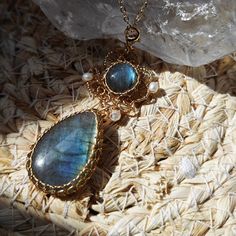 two necklaces sitting on top of a rock