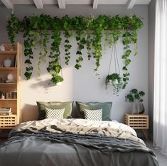 a bed covered in lots of green plants next to a wall mounted with hanging planters