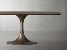 an oval dining table with a wooden top and metal base, on a grey background