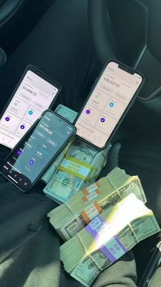 three cell phones sitting on top of each other next to money in a car seat