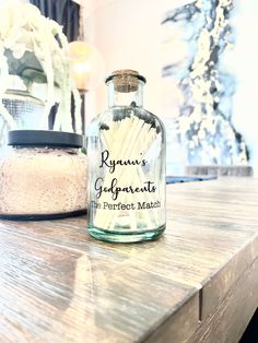 a glass bottle filled with matches sitting on top of a wooden table