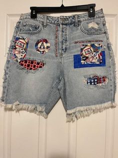 a pair of jean shorts with patches on them