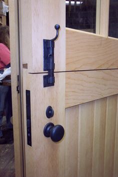 an image of a door handle on the side of a wooden door with black handles