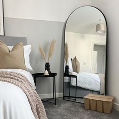 a bedroom with a bed and mirror in it