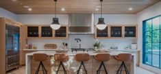 a kitchen with four bar stools in front of an island