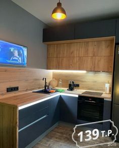 a kitchen with wooden cabinets and a flat screen tv on the wall