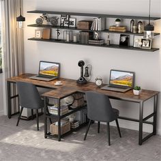 a computer desk with two laptops on top of it next to a book shelf