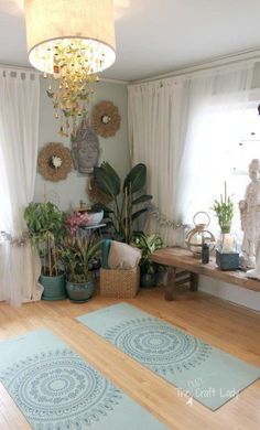 a living room filled with lots of plants and decor on top of hard wood floors