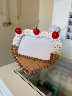 an ice cream sundae decorated with cherries and sprinkles is on display