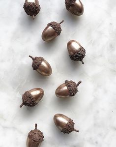 some brown acorns on a white marble surface