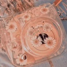 a glass plate with flowers on it sitting on a table next to a pair of scissors