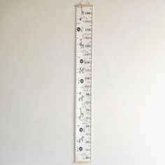 a ruler hanging on the wall in front of a white wall