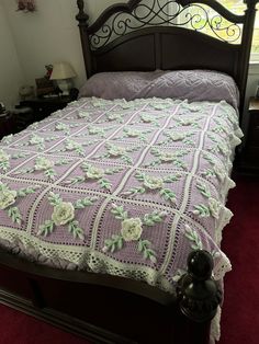 a bed with a crocheted bedspread on top of it