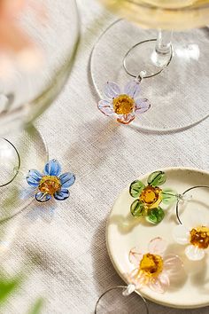 three wine glasses sitting on top of a table next to each other with flowers in them