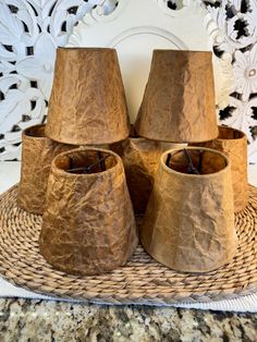 four brown paper cups sitting on top of a wicker basket