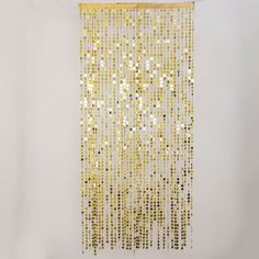 a wall hanging made out of gold colored beads