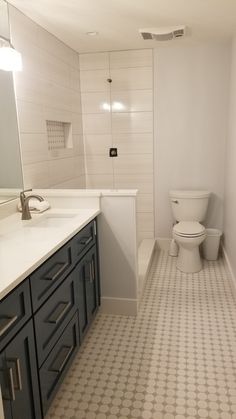 a bathroom with a toilet, sink, and mirror in it's center area