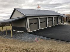 a two car garage sits in the middle of a gravel lot