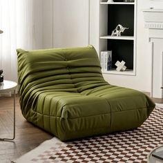 a living room filled with furniture and a rug on top of a hard wood floor