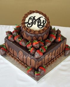 two tiered chocolate cake with strawberries on the bottom and monogrammed top