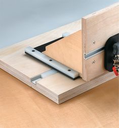 a piece of wood is attached to the back of a workbench with two screws